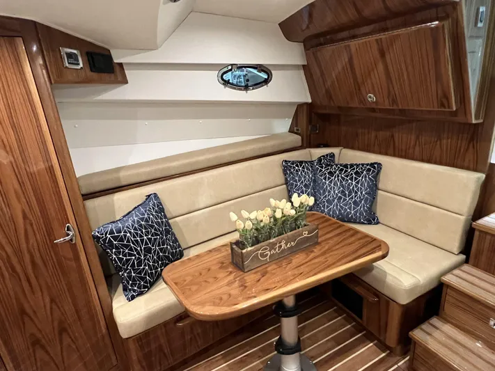  Yacht Photos Pics 2025 Henriques 35 Express Hardtop cabin with wood interior, beige seating, and decorative pillows.