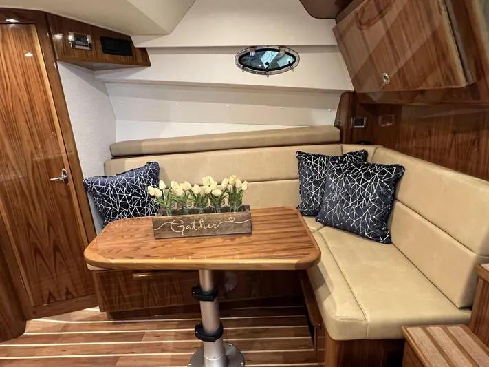  Yacht Photos Pics 2025 Henriques 35 Express Hardtop interior with wood finish, beige seating, and decorative pillows.