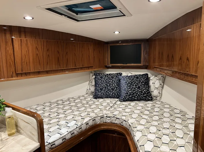  Yacht Photos Pics 2025 Henriques 35 Express Hardtop cabin with modern wood finish and geometric-patterned bedding.