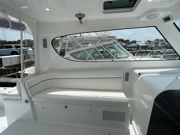  Yacht Photos Pics 2025 Henriques 35 Express Hardtop interior with white seating and window view of marina.