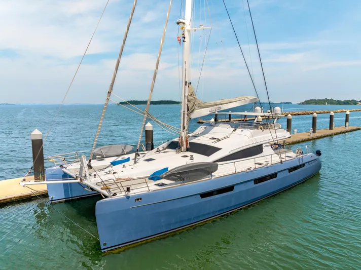Sur L'eau Yacht Photos Pics Luxury Privilege 745 catamaran docked, 2008 model, blue hull, calm waters, clear sky.