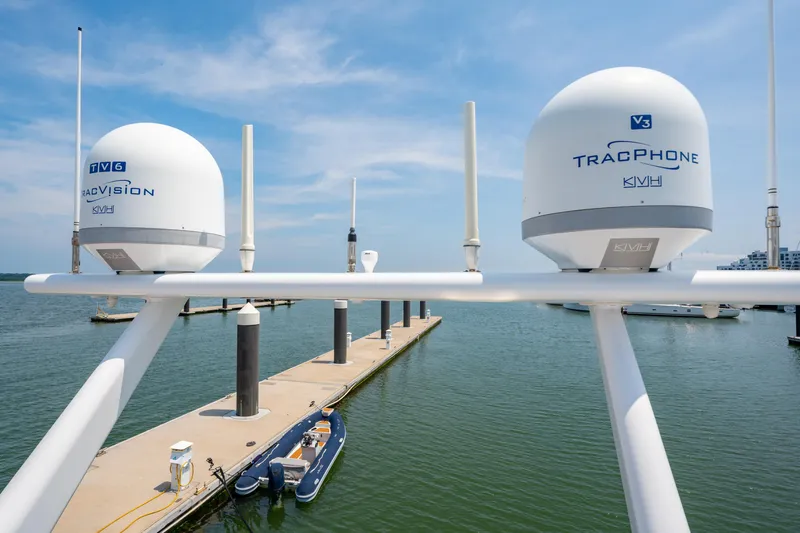 Sur L'eau Yacht Photos Pics Satellite domes on a Privilege 745 yacht, docked at a marina, under a clear blue sky.