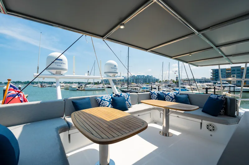 Sur L'eau Yacht Photos Pics Luxurious 2008 Privilege 745 yacht deck with seating, tables, and marina view.