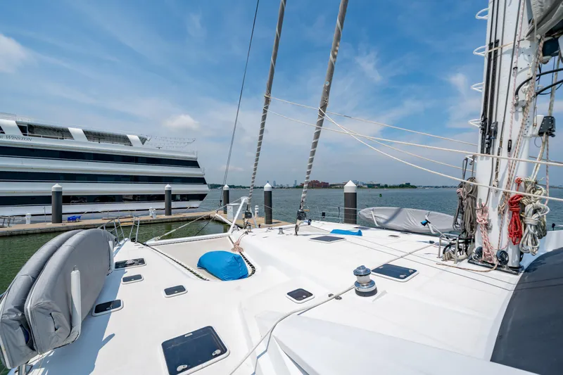 Sur L'eau Yacht Photos Pics Sailing yacht Privilege 745, 2008 model, docked near a large cruise ship on a sunny day.