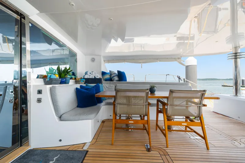 Sur L'eau Yacht Photos Pics Luxurious 2008 Privilege 745 yacht deck with seating, table, and ocean view.
