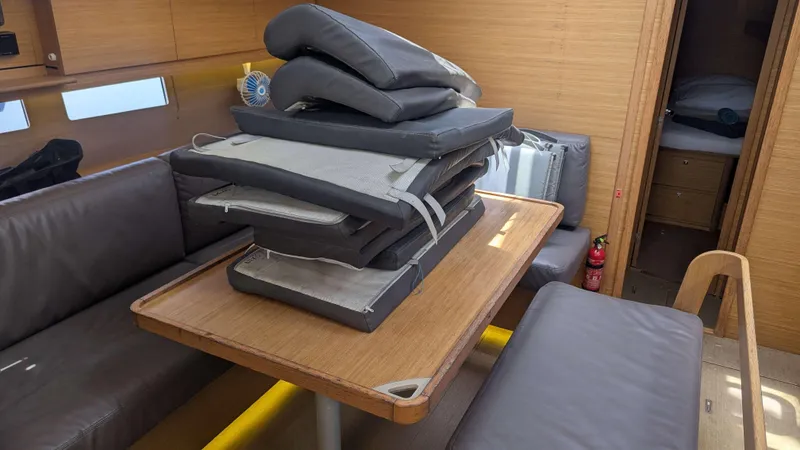 Nevis Yacht Photos Pics Interior of 2017 Dufour 460 Grand Large yacht with stacked cushions on table.