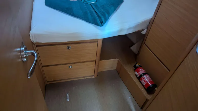 Nevis Yacht Photos Pics Cabin interior of 2017 Dufour 460 Grand Large with bed, drawers, and fire extinguisher.