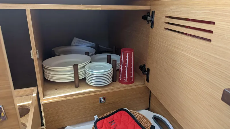 Nevis Yacht Photos Pics Cabinet with plates and measuring cup on Dufour 460 Grand Large yacht, 2017 model.