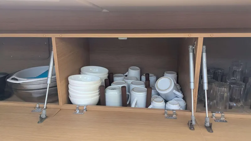 Nevis Yacht Photos Pics Cabinet with neatly arranged dishes and glasses on a 2017 Dufour 460 Grand Large yacht.