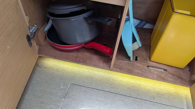 Nevis Yacht Photos Pics Cabinet storage on 2017 Dufour 460 Grand Large yacht with cookware and cleaning tools.