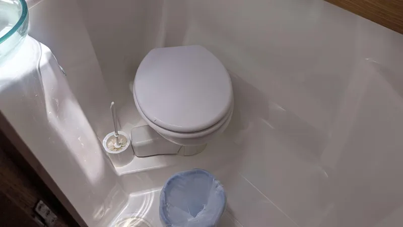 Nevis Yacht Photos Pics Compact bathroom in 2017 Dufour 460 Grand Large yacht with toilet and cleaning supplies.