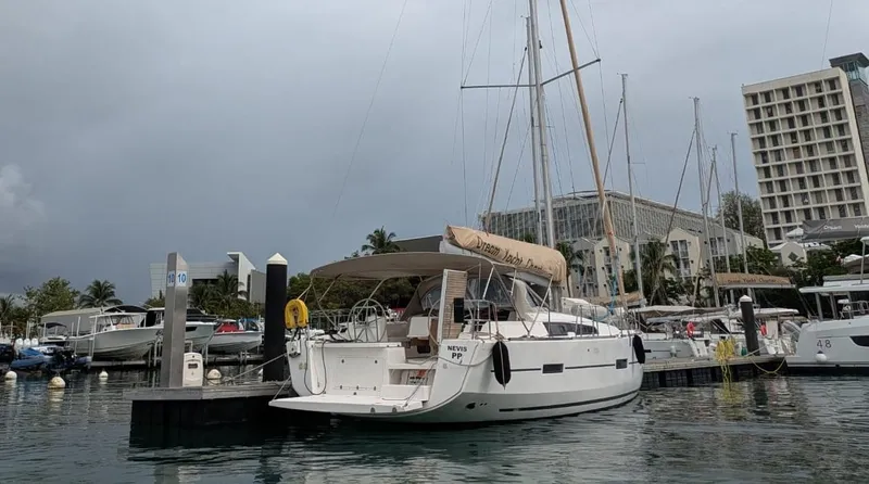Nevis Yacht Photos Pics 2017 Dufour 460 Grand Large yacht docked at marina, overcast sky, modern buildings in background.