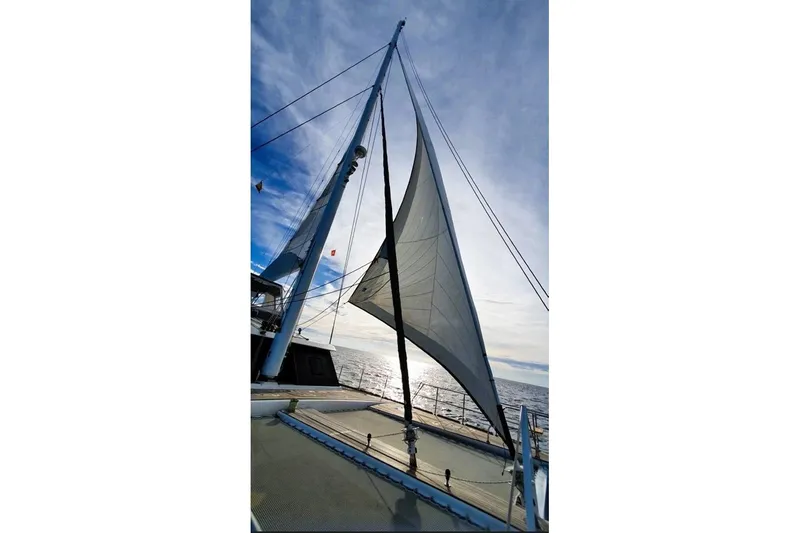 Sunnyacht Yacht Photos Pics Sailing on a 2008 Sunreef 62 catamaran with full sails against a clear sky.