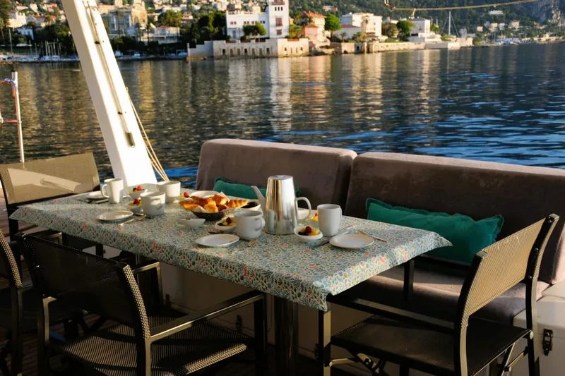 Sunnyacht Yacht Photos Pics Outdoor dining setup on 2008 Sunreef 62 yacht, overlooking serene waterfront scenery.