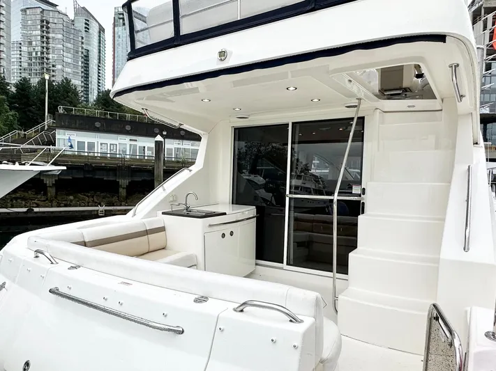  Yacht Photos Pics 2012 Sea Ray 450 Sedan Bridge yacht with outdoor seating and kitchenette, docked in urban marina.