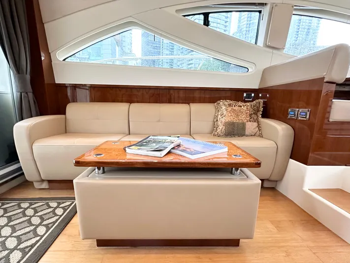  Yacht Photos Pics Luxurious interior of 2012 Sea Ray 450 Sedan Bridge yacht with beige sofa and wooden table.