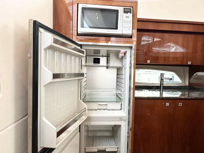  Yacht Photos Pics Open refrigerator and microwave in 2012 Sea Ray 450 Sedan Bridge yacht kitchen.