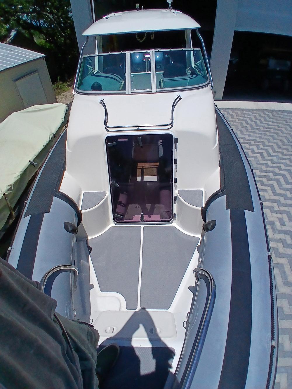 2002 Protector 28 Targa boat, top view, docked on patterned pavement.