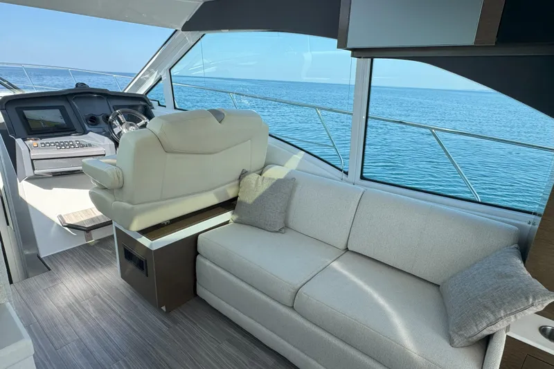  Yacht Photos Pics Interior of 2017 Cruisers Yachts 45 Cantius with helm and sofa, overlooking ocean.