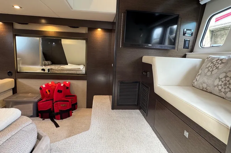  Yacht Photos Pics Luxurious interior of 2017 Cruisers Yachts 45 Cantius with TV, seating, and life jackets.