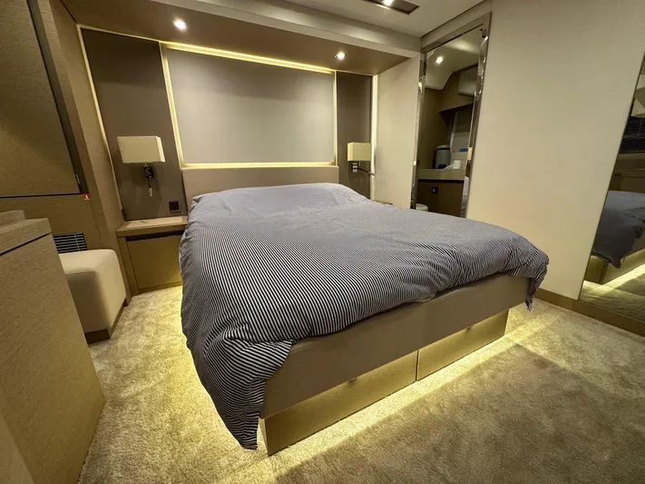  Yacht Photos Pics Luxurious bedroom interior of a 2017 Prestige 680 yacht with modern lighting and striped bedding.