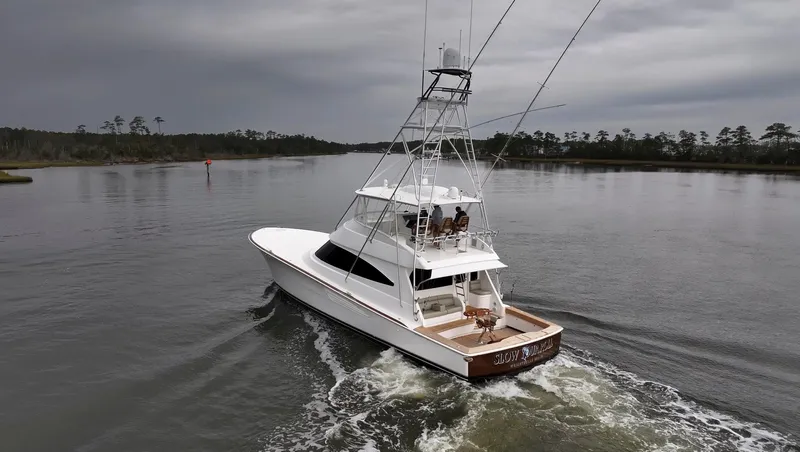 Slow Your Roll Yacht Photos Pics 2019 Viking 68 Convertible yacht cruising on a calm river under cloudy skies.