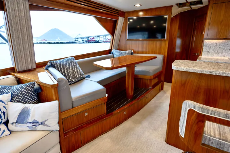 Slow Your Roll Yacht Photos Pics Luxurious interior of 2019 Viking 68 Convertible yacht with elegant wood finish and seating area.