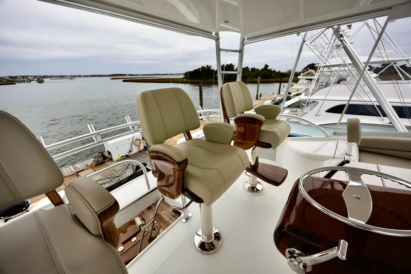 Slow Your Roll Yacht Photos Pics Luxurious 2019 Viking 68 Convertible yacht interior with plush seating and scenic water view.