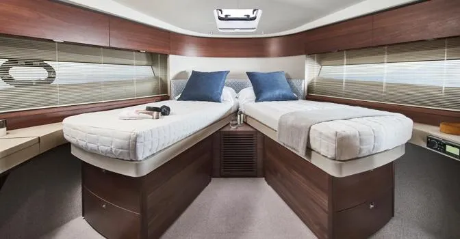  Yacht Photos Pics Luxurious 2024 Princess F50 yacht cabin with twin beds and elegant wood finish.