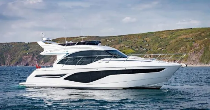  Yacht Photos Pics 2024 Princess F50 yacht cruising on the ocean near a scenic coastline.