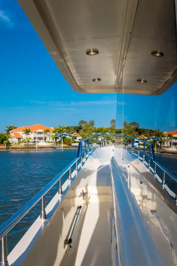  Yacht Photos Pics Luxury yacht deck view, Alaska 59 Sedan 2026, with waterfront homes in the background.
