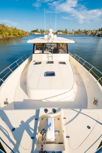  Yacht Photos Pics 2026 Alaska 59 Sedan yacht cruising on a sunny river with clear blue skies.