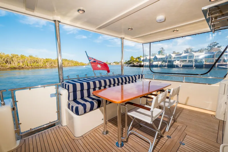  Yacht Photos Pics Luxurious 2026 Alaska 59 Sedan yacht interior with striped seating and scenic waterfront view.