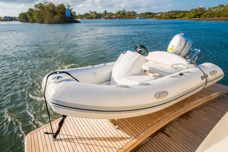  Yacht Photos Pics A white inflatable boat on a wooden dock by a scenic lake.