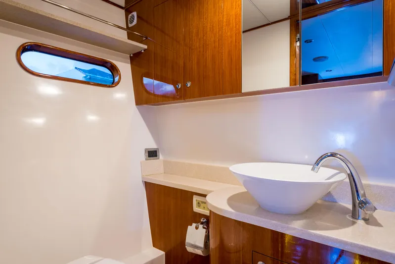  Yacht Photos Pics Luxurious bathroom interior of 2026 Alaska 59 Sedan yacht with modern sink and wooden cabinetry.