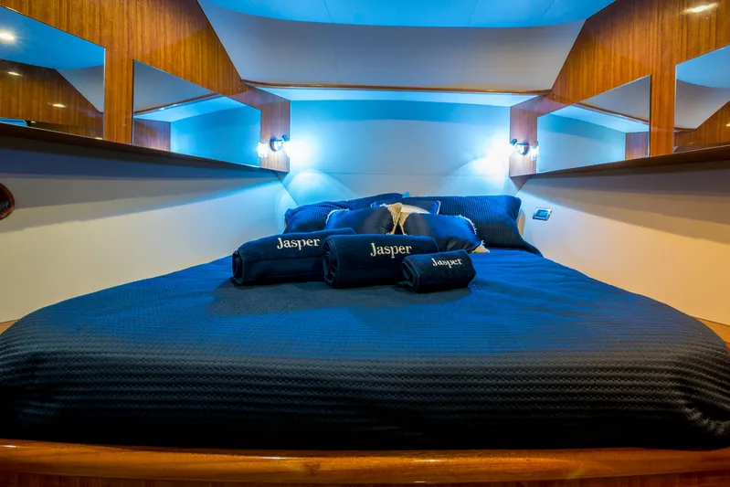  Yacht Photos Pics Luxurious bedroom interior of 2026 Alaska 59 Sedan yacht with blue bedding and ambient lighting.