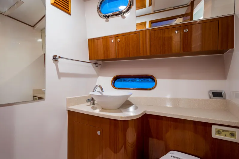  Yacht Photos Pics Luxurious bathroom interior of 2026 Alaska 59 Sedan yacht with wooden cabinets and modern fixtures.