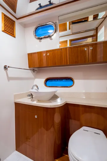  Yacht Photos Pics Luxurious bathroom in 2026 Alaska 59 Sedan yacht with wooden cabinetry and modern fixtures.