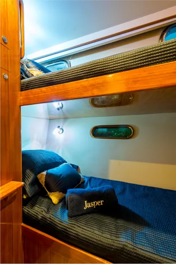  Yacht Photos Pics Bunk beds in 2026 Alaska 59 Sedan, featuring cozy bedding and wooden accents.