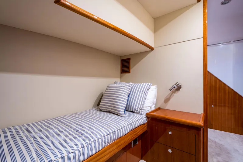  Yacht Photos Pics 2026 Alaska 59 Sedan interior cabin with striped bedding and wooden furnishings.