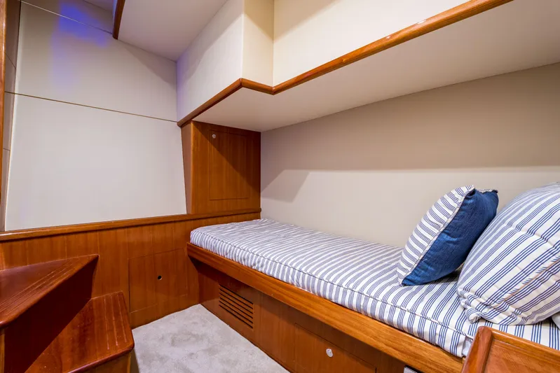  Yacht Photos Pics Interior cabin of 2026 Alaska 59 Sedan yacht with striped bedding and wooden accents.