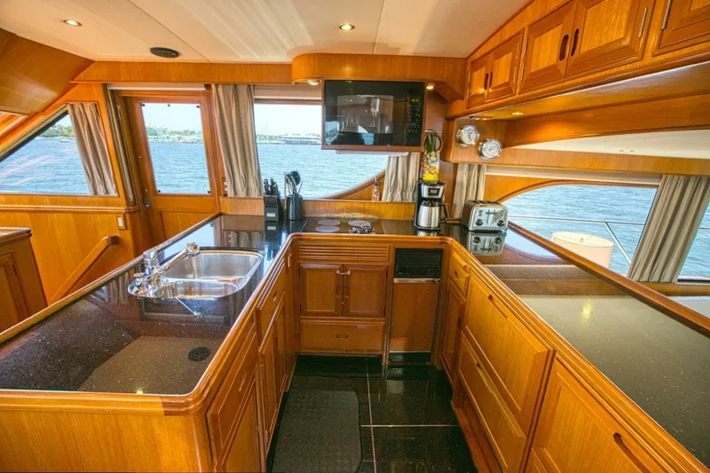 The Cotton Picker Yacht Photos Pics Luxurious kitchen interior of 2000 Ocean Alexander 610 Pilothouse yacht with wood cabinetry and ocean view.