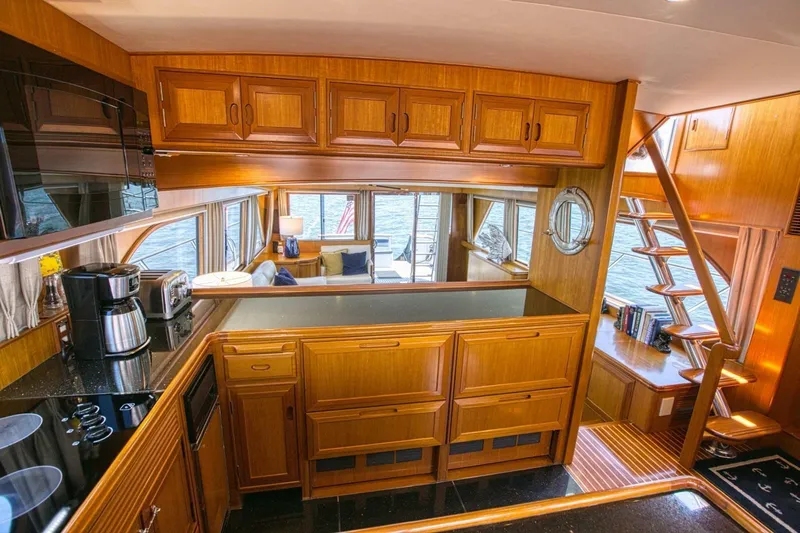 The Cotton Picker Yacht Photos Pics Luxurious interior of 2000 Ocean Alexander 610 Pilothouse yacht with wooden cabinetry and modern amenities.