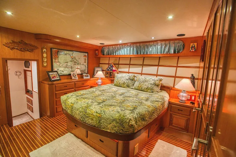 The Cotton Picker Yacht Photos Pics Luxurious bedroom interior of 2000 Ocean Alexander 610 Pilothouse yacht with wood accents and cozy lighting.