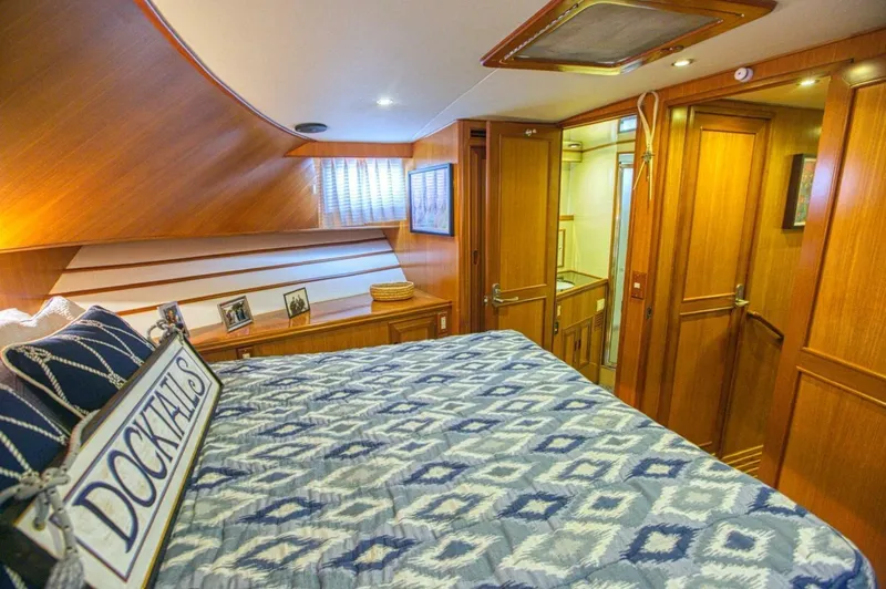 The Cotton Picker Yacht Photos Pics Luxurious cabin interior of 2000 Ocean Alexander 610 Pilothouse yacht with wood paneling and cozy bedding.