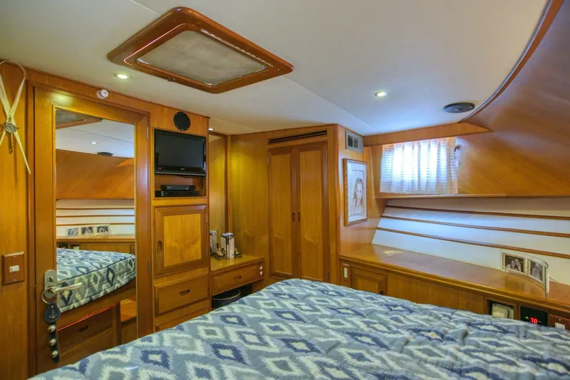 The Cotton Picker Yacht Photos Pics Luxurious cabin interior of 2000 Ocean Alexander 610 Pilothouse yacht with wood paneling and cozy bedding.