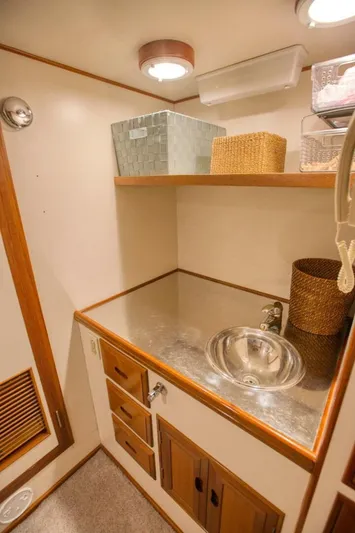 The Cotton Picker Yacht Photos Pics Small bathroom sink area on 2000 Ocean Alexander 610 Pilothouse yacht, featuring storage and baskets.