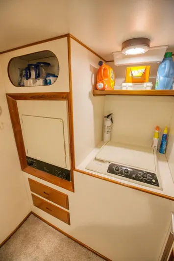 The Cotton Picker Yacht Photos Pics Laundry area in 2000 Ocean Alexander 610 Pilothouse with washer, dryer, and storage shelves.
