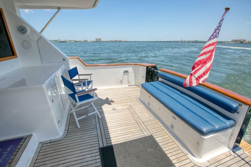 The Cotton Picker Yacht Photos Pics Ocean Alexander 610 Pilothouse 2000 yacht deck with seating, American flag, and ocean view.