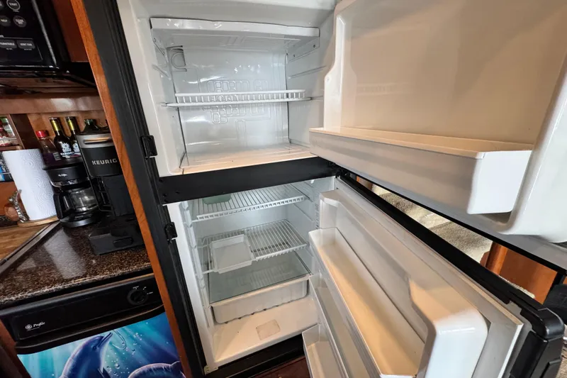  Yacht Photos Pics Open refrigerator in 2006 Meridian 490 Pilothouse yacht kitchen, showcasing interior storage space.